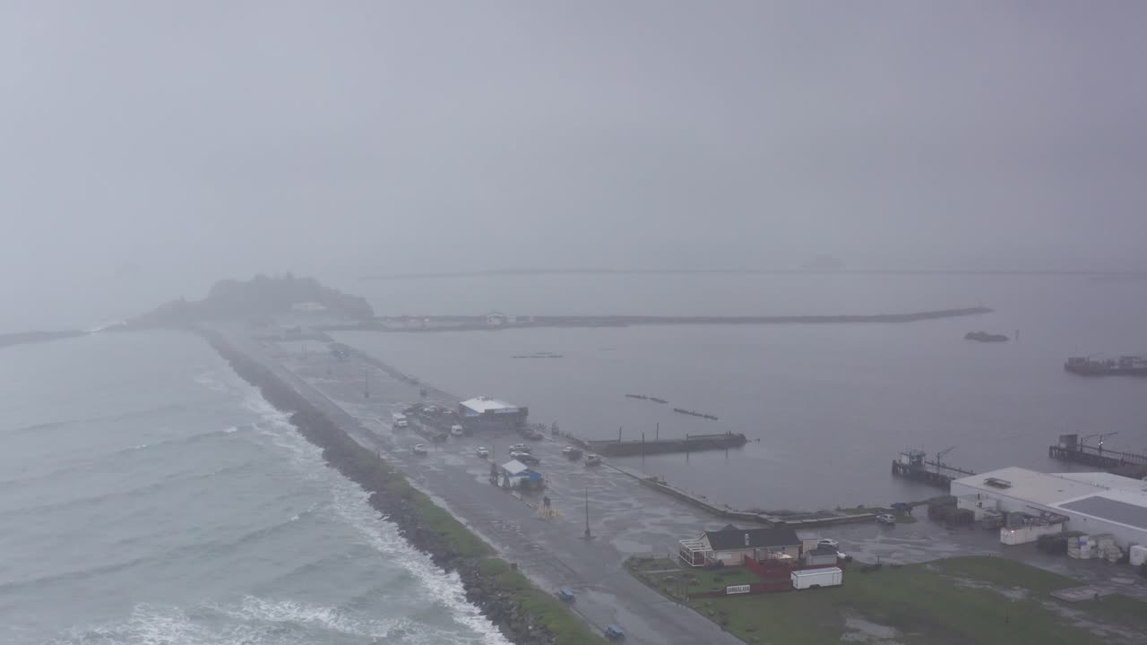 Aerial wide panning shot of Crescent Harbor during a storm in Crescent City, California. 4K