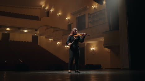 female-violinist-is-playing-violin-in-music-school-or-dark-music-hall-full-length-portrait-of-musician