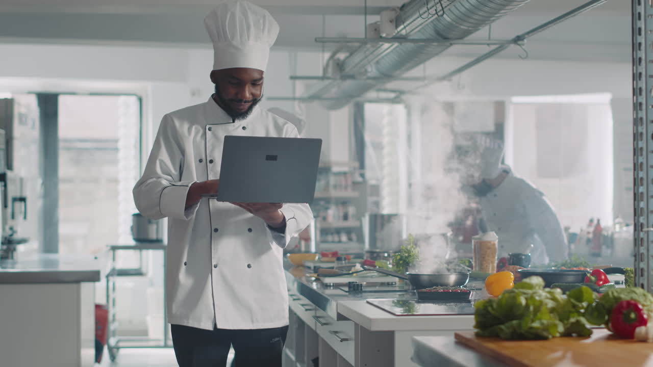 African american chef cooking culinary recipe with laptop