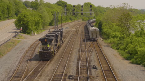 trains-engine-backing-up-on-the-railroad-tracks-with-another-train-pulling-away