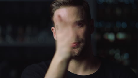 Portrait-of-handsome-young-man-swiping-on-invisible-multi-touch-screen-in-office