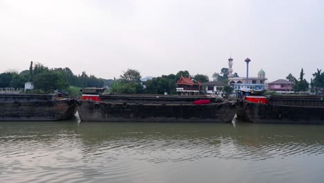 tugboat moving along ayutthaya riverbank