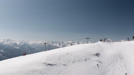 Luftdrohnenaufnahme-Von-Skifahrern,-Die-Mit-Dem-Skilift-Auf-Den-Berg-Fahren