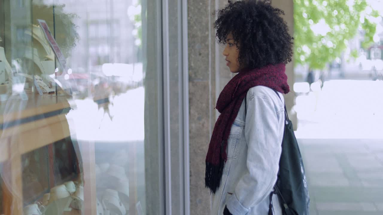 가게 창문을 바라보는 젊은 여자