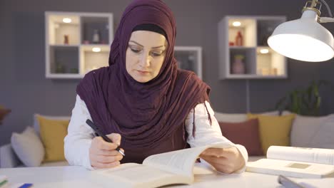 muslim female student wearing hijab is studying for her lessons.