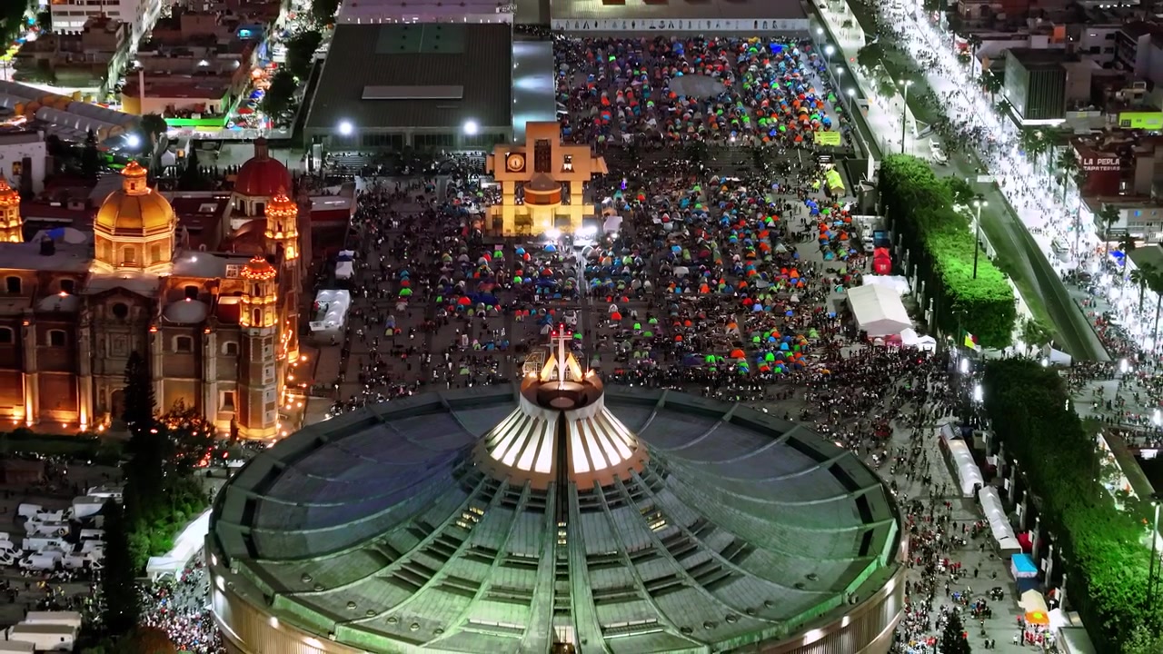 Basilica di Guadalupe di notte che mostra migliaia di pellegrini accampati nella piazza durante la celebrazione del 12 dicembre per la Vergine di Guadalupe a Città del Messico, vista aerea con drone.