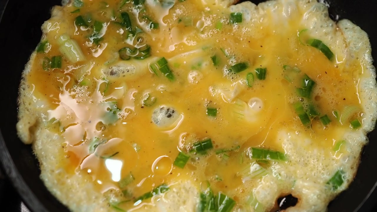 Scrambled Eggs with Green Onions Cooking in a Frying Pan