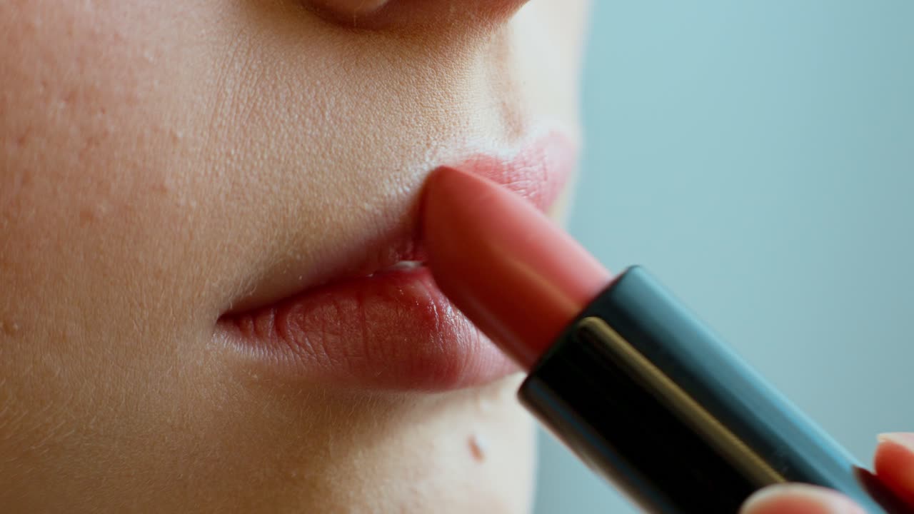 mujer aplicando lápiz labial