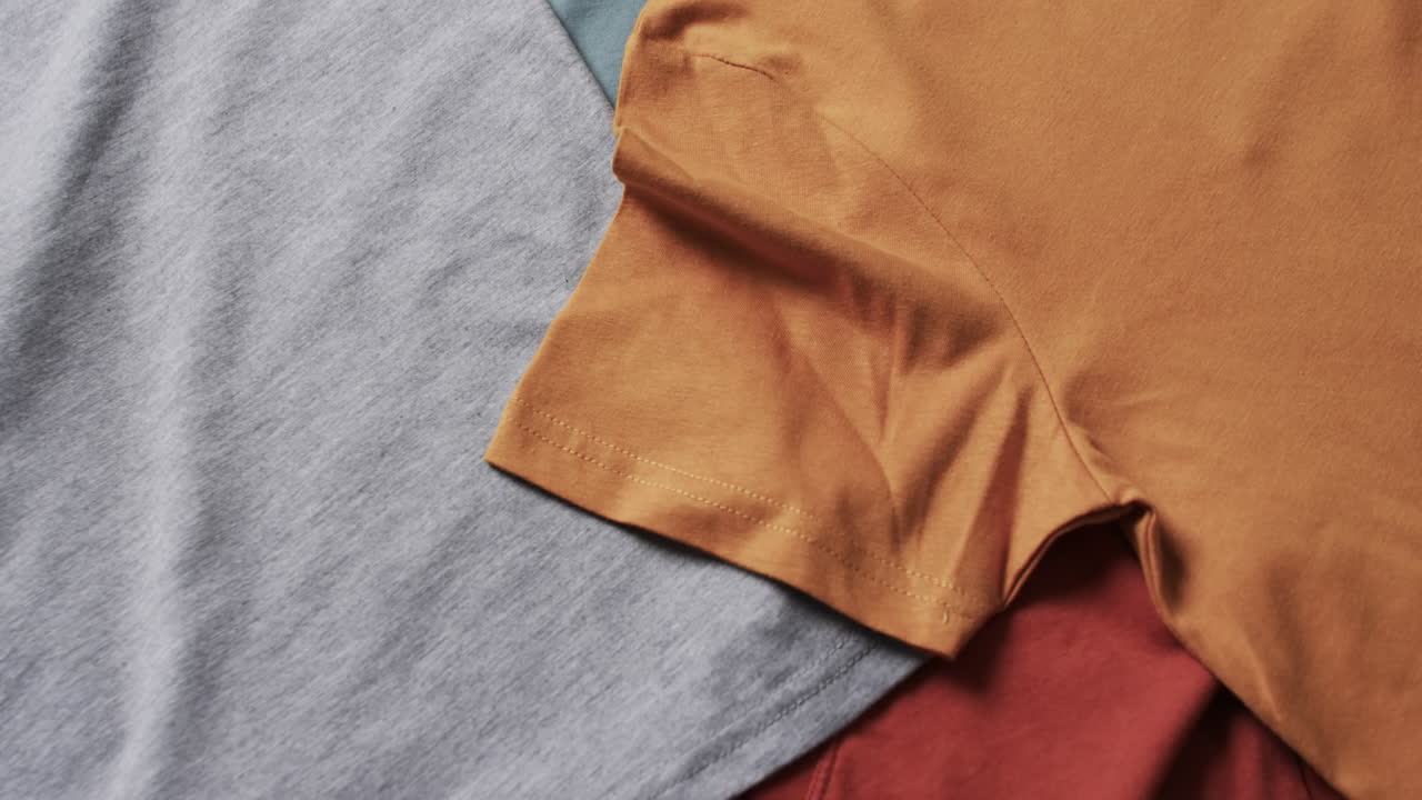 ⁇ 색 배경에 복사 공간이 있는 다채로운 티셔츠의 평평한 레이의 비디오