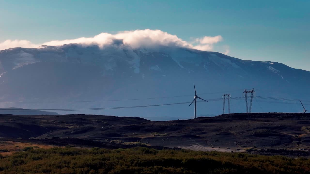 Wind Turbines With Hekla Volcano In The Background In South Iceland. - wide shot