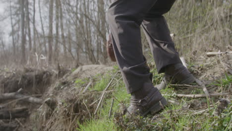 cowboy walking down to a river to fill up his canteen