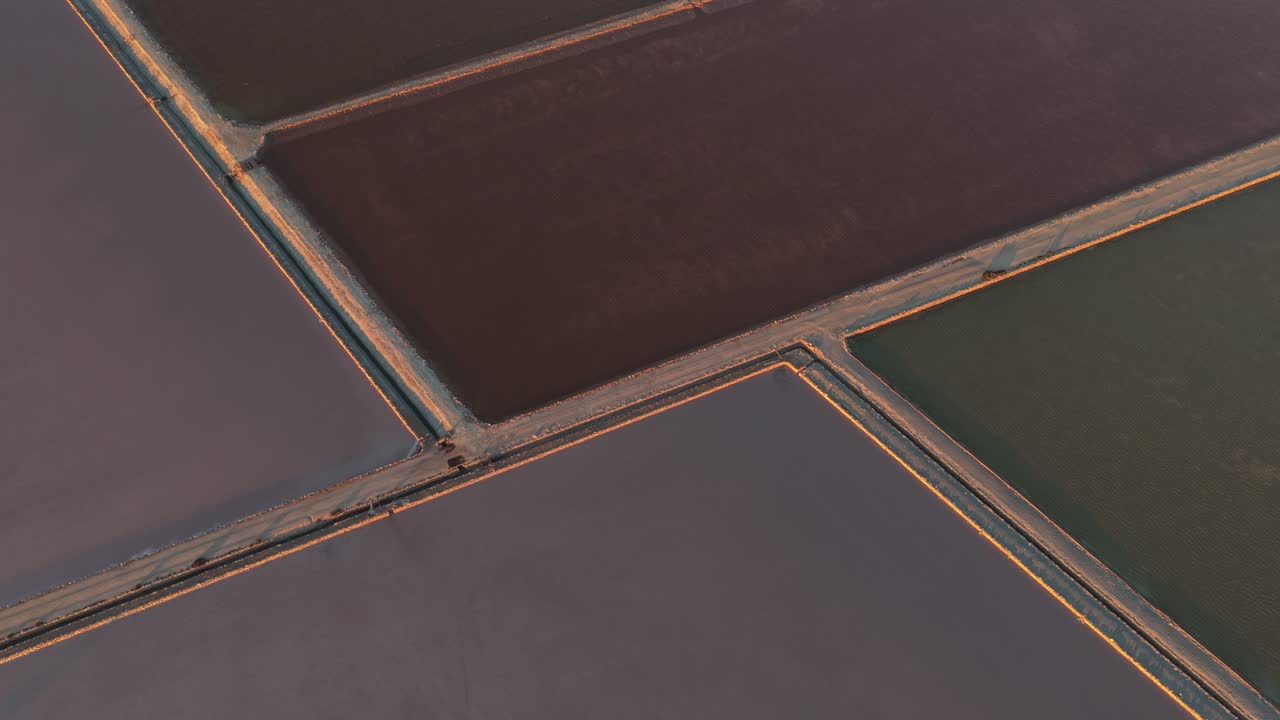 Drone flying above colorful salt evaporation ponds