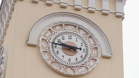 reloj del zodiaco ornamentado en una torre de edificio beige