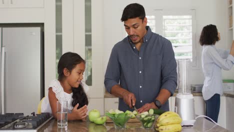 Padre-Hispano-Enseñando-A-Su-Hija-Sonriente-A-Cocinar-En-La-Cocina