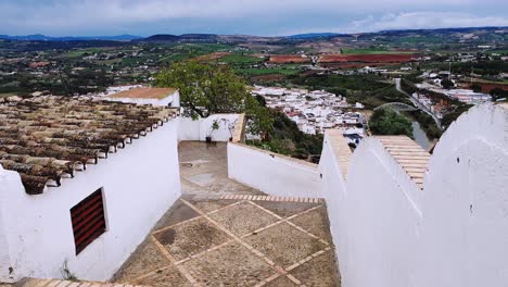 View-along-white-walls-and-the-valley-of-Arcos-de-la-frontera-a-famous-pueblo-blanco-of-Andalusia,-Spain