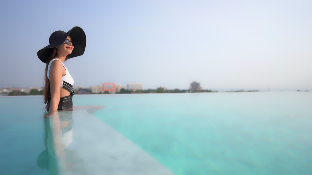 Content happy asian model enjoying rich luxurious life at pool