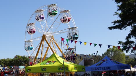 a ferris wheel rotates at a vibrant outdoor fair