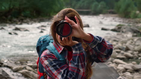 girl photographing in mountains. female professional taking photos outdoor