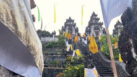 lempuyang temple steps with yellow and white flags, tilt up view in bali, indonesia.