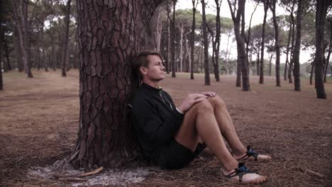 lonely solo man with pine tree against his back - stranded and alone