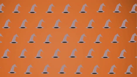 animation of falling witchs hats on orange background