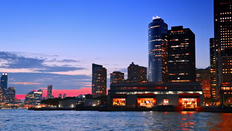luminous skyline of a big city at night time. river cruise by the east river in new york, usa