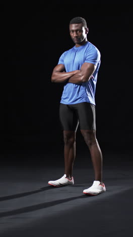 vertical video: african american male athlete posing confidently, black background