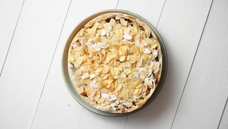 Freshly-baked-homemade-apple-pie-with-almond-flakes-cake-on-yellow