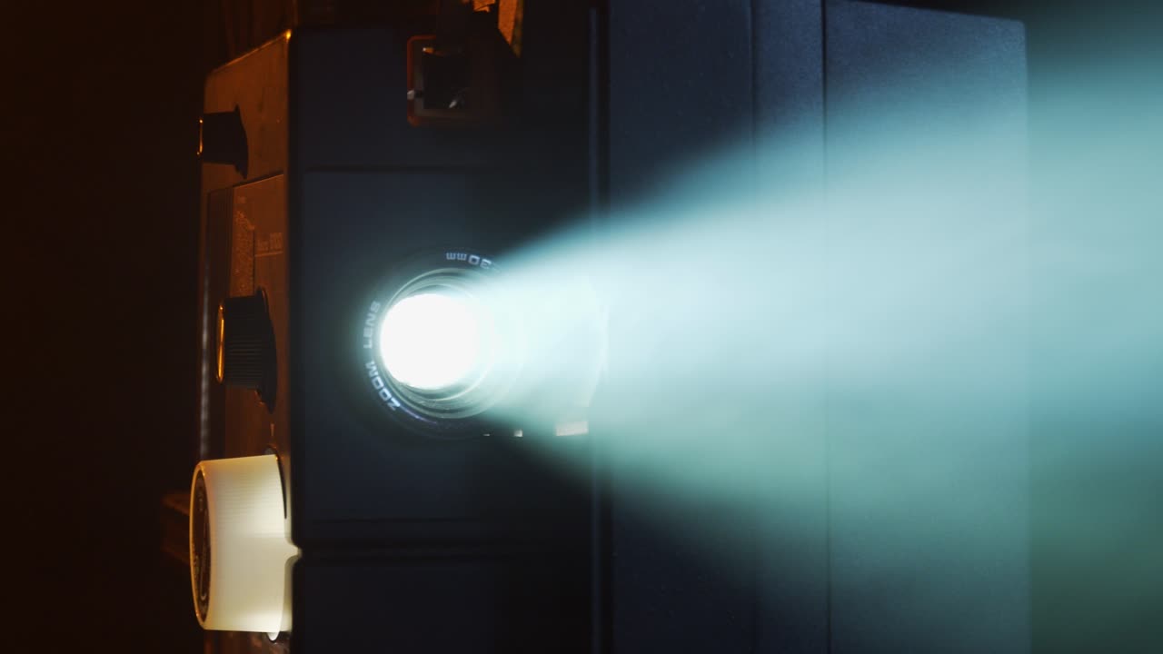 Super-8 movie projector shows old home movies in a smokey room