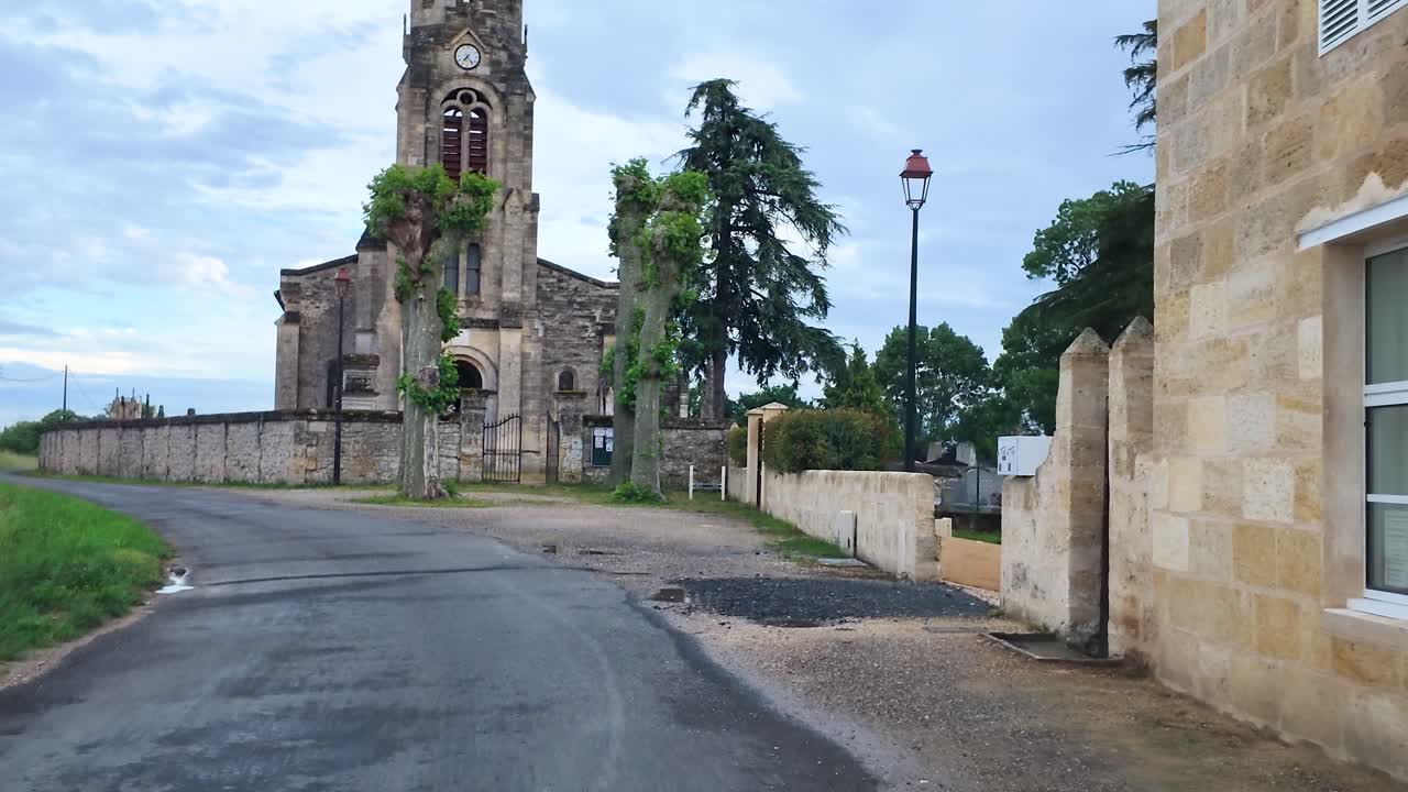 Un lento movimento della telecamera si avvicina a una storica chiesa in pietra e al suo campanile a Bordeaux, Francia.