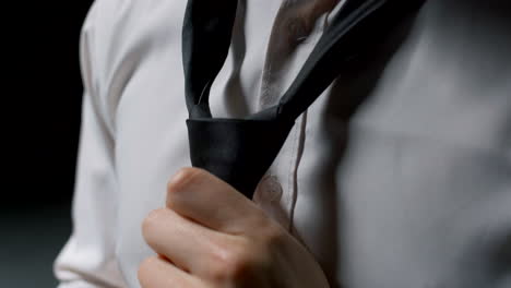 man adjusting necktie