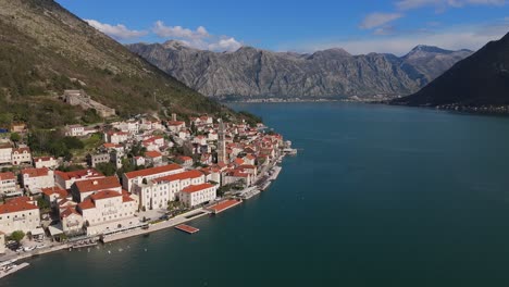 4K-Drohnenaufnahmen-Zeigen-Die-St.-Nikolaus-Kirche-In-Der-Bezaubernden-Stadt-Perast-In-Montenegro,-Mit-Einem-Wunderschönen-Blick-Auf-Die-Türkisfarbene-Bucht-Von-Kotor,-Die-Zum-UNESCO-Weltkulturerbe-Gehört,-Und-Die-Berge-Im-Hintergrund