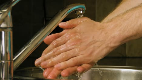 washing hands and rinsing with water in a home kitchen sink slow motion