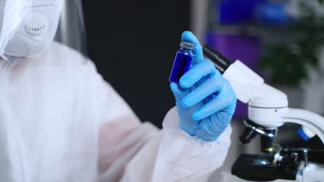 scientist examining vial in laboratory