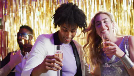 video of happy diverse couple dancing holding glasses of champagne at a nightclub