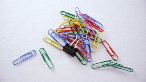 various paper clips on white background 4k