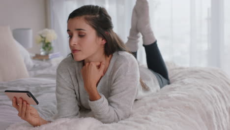 happy-woman-using-smartphone-texting-browsing-social-media-messages-enjoying-mobile-phone-communication-lying-on-bed-at-home