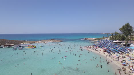 aerial shot of a beautiful sandy beach with a small island, watersports and beach facilities