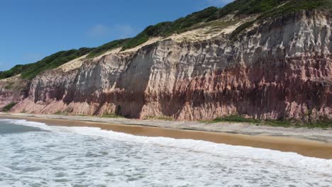 colorida playa brasileña junto al acantilado en el desierto del noreste durante la marea alta
