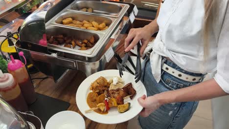 woman serving herself at a buffet