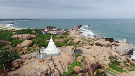 templo de estupa blanca en la parte superior de la roca en la costa de sri lanka con el océano en el fondo