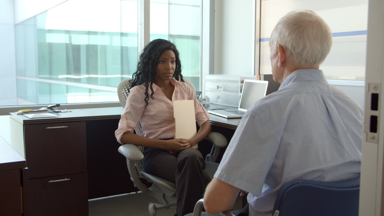 Female Doctor In Meeting With Male Patient In Office