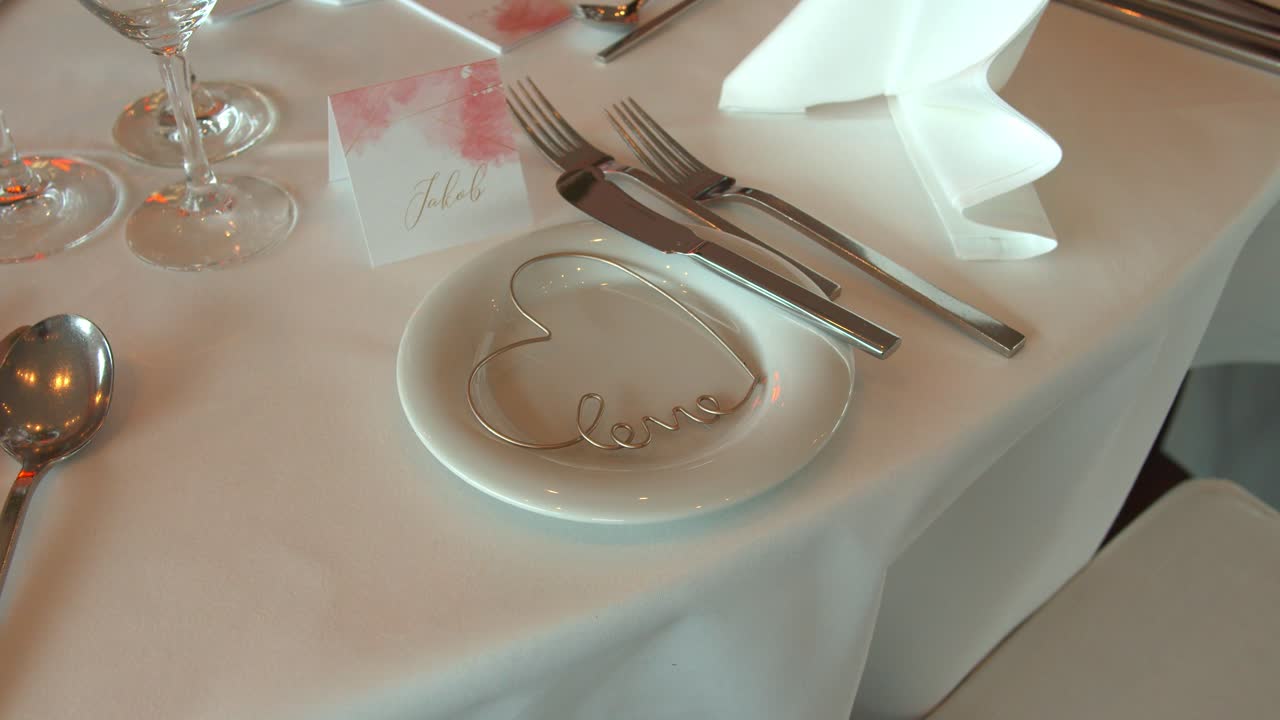 mantel blanco con tarjeta de nombre y forma de corazón en plato blanco en boda festiva