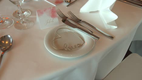 white tablecloth with name card and heart shape in white plate in wedding festive