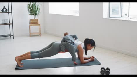 mother and baby doing plank exercise at home