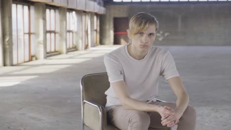 young trendy man sitting on chair in hall