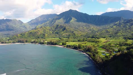 Impresionante-Toma-Panorámica-Aérea-De-La-Bahía-De-Hanalei-Y-El-Valle-De-Hanalei-Y-Montañas-Verdes-Con-El-Río-Hanalei-Cerca-De-Princeville,-Kauai,-Hawaii