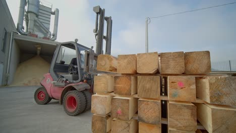 forklift stocking tree trunks in pile one over each other