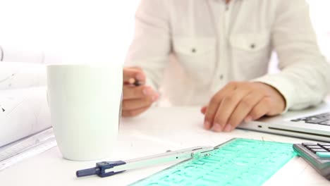 arquitecto trabajando dibujando en un proyecto con té