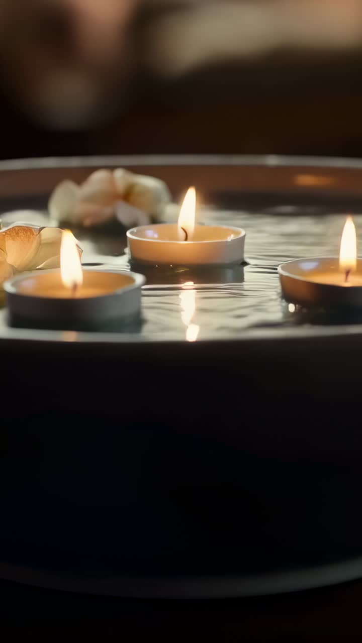 Dikey video: Kamera metal tealight, kasede titriyor, yapraklar alevi yansıtarak odağına alıyor